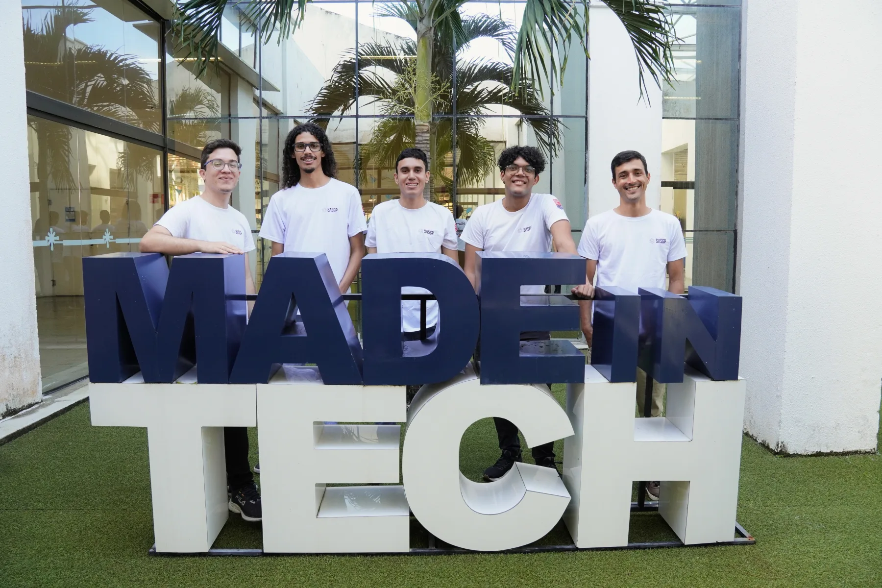 Equipe de desenvolvimento da SASGP reunida atrás do letreiro Made in Tech